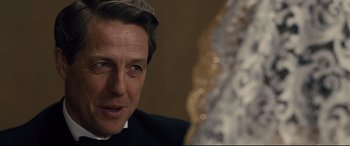 Movie still from “Florence Foster Jenkins” (2016), directed by Stephen Frears – A person wearing a suit and a hat; Close Up shot, Over the shoulder angle