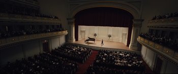 Movie still from “Florence Foster Jenkins” (2016), directed by Stephen Frears – An audience is sitting in front of a stage with a grand piano on it; Extreme Wide shot, High angle