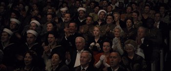 Movie still from “Florence Foster Jenkins” (2016), directed by Stephen Frears – A group of people sitting in a room clapping; Medium shot, High angle