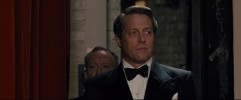 Movie still from “Florence Foster Jenkins” (2016), directed by Stephen Frears – A person wearing a suit and a bow tie; Close Up shot, Over the shoulder angle