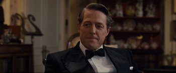 Movie still from “Florence Foster Jenkins” (2016), directed by Stephen Frears – A person wearing a suit and bow tie; Close Up shot, Over the shoulder angle