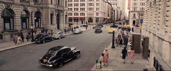 Movie still from “Florence Foster Jenkins” (2016), directed by Stephen Frears – An old fashioned car is driving down the street; Extreme Wide shot, High angle