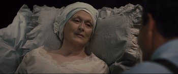 Movie still from “Florence Foster Jenkins” (2016), directed by Stephen Frears – An older woman wearing a head scarf laying on a couch; Close Up shot, Overhead angle