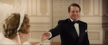 Movie still from “Florence Foster Jenkins” (2016), directed by Stephen Frears – A man in a tuxedo holding his hand out to someone; Medium shot, Low angle