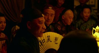 Movie still from “Flowers of Shanghai” (1998), directed by Hsiao-Hsien Hou – A group of men sitting next to each other holding a fan; Close Up shot, Over the shoulder angle