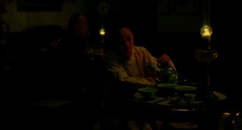 Movie still from “Flowers of Shanghai” (1998), directed by Hsiao-Hsien Hou – A person sitting at a table with a teapot; Medium shot, High angle