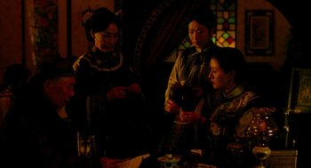 Movie still from “Flowers of Shanghai” (1998), directed by Hsiao-Hsien Hou – A group of women standing around a table; Medium shot, Over the shoulder angle