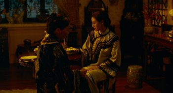 Movie still from “Flowers of Shanghai” (1998), directed by Hsiao-Hsien Hou – Two women sitting at a table talking to each other; Medium shot, High angle