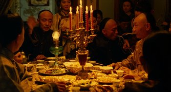Movie still from “Flowers of Shanghai” (1998), directed by Hsiao-Hsien Hou – A group of people sitting around a dinner table; Medium shot, High angle