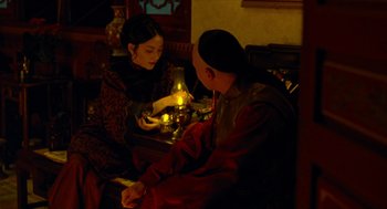 Movie still from “Flowers of Shanghai” (1998), directed by Hsiao-Hsien Hou – A man and a woman sitting at a table with candles; Medium shot, High angle