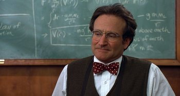 Movie still from “Flubber” (1997), directed by Les Mayfield – A man in a bow tie standing in front of a chalkboard; Close Up shot, Over the shoulder angle