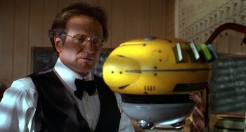Movie still from “Flubber” (1997), directed by Les Mayfield – A man in a suit and tie next to a yellow helmet; Close Up shot, Low angle