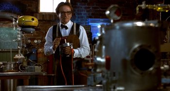 Movie still from “Flubber” (1997), directed by Les Mayfield – A man in a white dress shirt and bow tie holding an electric drill; Medium shot, Low angle