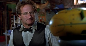 Movie still from “Flubber” (1997), directed by Les Mayfield – A man in a vest and bow tie looking at a ball; Close Up shot, Low angle