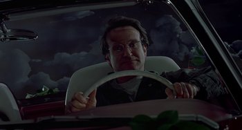 Movie still from “Flubber” (1997), directed by Les Mayfield – A man driving a car at night in the dark; Close Up shot, Low angle