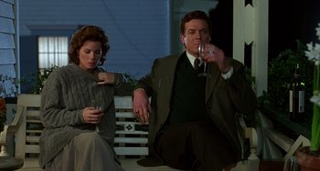 Movie still from “Flubber” (1997), directed by Les Mayfield – A man and a woman sitting on a bench drinking wine; Medium shot, Low angle