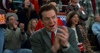 Movie still from “Flubber” (1997), directed by Les Mayfield – A man wearing a suit and red tie clapping in front of a group of people; Close Up shot, Low angle