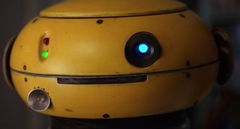 Movie still from “Flubber” (1997), directed by Les Mayfield – A blue button on the side of a yellow object; Extreme Close Up shot, Overhead angle