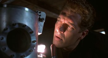 Movie still from “Flubber” (1997), directed by Les Mayfield – A person looking at a piece of metal; Close Up shot, Low angle