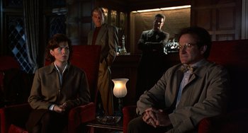 Movie still from “Flubber” (1997), directed by Les Mayfield – A group of people sitting in a room; Medium shot, Over the shoulder angle