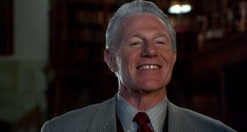 Movie still from “Flubber” (1997), directed by Les Mayfield – An older man wearing a suit and tie smiling; Close Up shot, Low angle