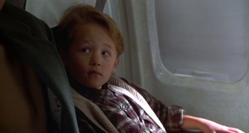 Movie still from “Flubber” (1997), directed by Les Mayfield – A little boy sitting in a seat on an airplane; Close Up shot, High angle