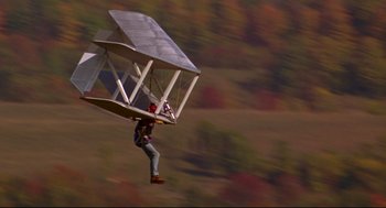 Movie still from “Fly Away Home” (1996), directed by Carroll Ballard – A man flying a kite in the air; Wide shot, Low angle