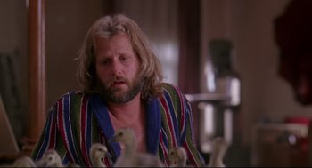 Movie still from “Fly Away Home” (1996), directed by Carroll Ballard – A man with long hair and a beard sitting in front of a group of birds; Close Up shot, Low angle