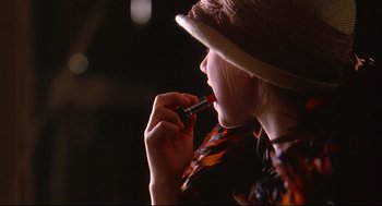 Movie still from “Fly Away Home” (1996), directed by Carroll Ballard – A woman is putting lipstick in her mouth; Extreme Close Up shot, Over the shoulder angle