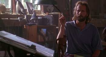 Movie still from “Fly Away Home” (1996), directed by Carroll Ballard – A man sitting at a table with a lamp in front of him; Medium shot, Low angle