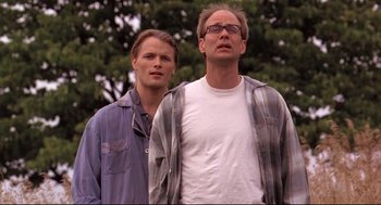 Movie still from “Fly Away Home” (1996), directed by Carroll Ballard – Two men standing next to each other in front of a tree; Medium shot, Low angle