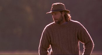 Movie still from “Fly Away Home” (1996), directed by Carroll Ballard – A man wearing a hat and a sweater walking; Medium shot, Low angle