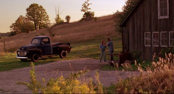 Movie still from “Fly Away Home” (1996), directed by Carroll Ballard – Two people standing in front of an old truck; Wide shot, Over the shoulder angle