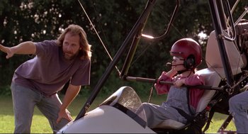 Movie still from “Fly Away Home” (1996), directed by Carroll Ballard – A man standing next to a person sitting in an airplane; Medium shot, Low angle