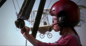 Movie still from “Fly Away Home” (1996), directed by Carroll Ballard – A person wearing a red helmet is holding a remote control; Close Up shot, Low angle