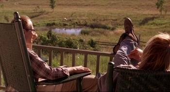 Movie still from “Fly Away Home” (1996), directed by Carroll Ballard – Two people are sitting on a deck and one person is laying on the ground; Wide shot, Low angle