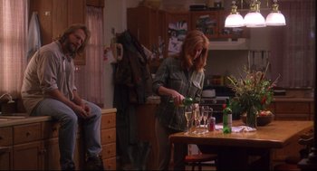 Movie still from “Fly Away Home” (1996), directed by Carroll Ballard – Two people sitting at a table with wine glasses on it; Wide shot, Over the shoulder angle