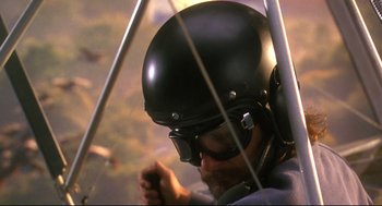 Movie still from “Fly Away Home” (1996), directed by Carroll Ballard – A man wearing a black helmet while sitting in an airplane; Close Up shot, Low angle