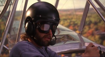 Movie still from “Fly Away Home” (1996), directed by Carroll Ballard – A man wearing a helmet and goggles in the cockpit of an airplane; Close Up shot, Low angle