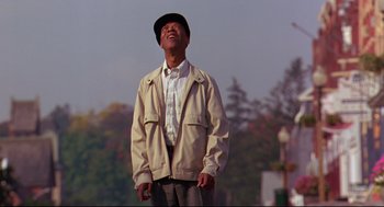 Movie still from “Fly Away Home” (1996), directed by Carroll Ballard – An older man wearing a hat looking up at the sky; Medium shot, Low angle