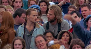 Movie still from “Fly Away Home” (1996), directed by Carroll Ballard – A man and a woman standing next to each other in front of a group of people; Medium shot, Over the shoulder angle