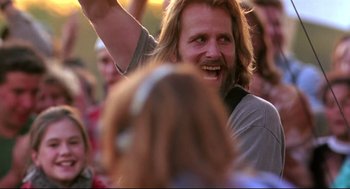 Movie still from “Fly Away Home” (1996), directed by Carroll Ballard – A man with long hair and a goatee is smiling; Close Up shot, Low angle
