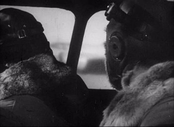 Movie still from “Flying Tigers” (1942), directed by David Miller – A man in a gas mask in the backseat of a car; Close Up shot, Low angle