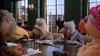 Movie still from “Follow That Bird” (1985), directed by Ken Kwapis – A group of stuffed animals sitting on top of a wooden table; Medium shot, Low angle