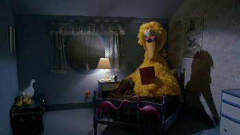 Movie still from “Follow That Bird” (1985), directed by Ken Kwapis – The big bird is sitting on the bed; Wide shot, High angle