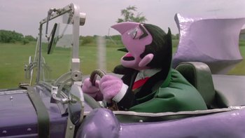 Movie still from “Follow That Bird” (1985), directed by Ken Kwapis – A stuffed animal sitting in the driver's seat of a car; Medium shot, Low angle