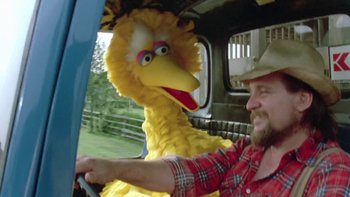 Movie still from “Follow That Bird” (1985), directed by Ken Kwapis – A big yellow bird sitting on top of a truck; Medium shot, Low angle