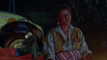 Movie still from “Follow That Bird” (1985), directed by Ken Kwapis – A woman sitting in front of a stuffed animal; Medium shot, Over the shoulder angle