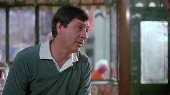 Movie still from “Follow That Bird” (1985), directed by Ken Kwapis – A person sitting in front of a window; Close Up shot, Over the shoulder angle