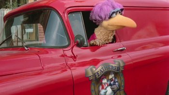 Movie still from “Follow That Bird” (1985), directed by Ken Kwapis – A stuffed animal sitting in the drivers seat of a red truck; Wide shot, High angle